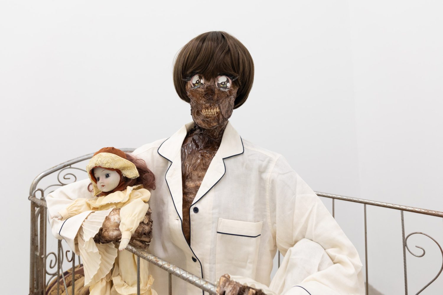 Julien Ceccaldi, Growing up Gay, 2026, Crib, comforter, plastic skeleton, melted drop cloth, wood stain, wig, acrylic paint on duralar, fake eyelashes, pyjama, and video game controller, courtesy of COOPER COLE