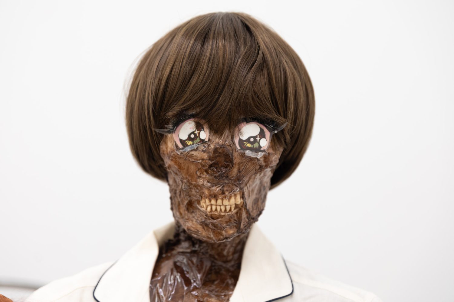 Julien Ceccaldi, Growing up Gay, 2026, Crib, comforter, plastic skeleton, melted drop cloth, wood stain, wig, acrylic paint on duralar, fake eyelashes, pyjama, and video game controller, courtesy of COOPER COLE