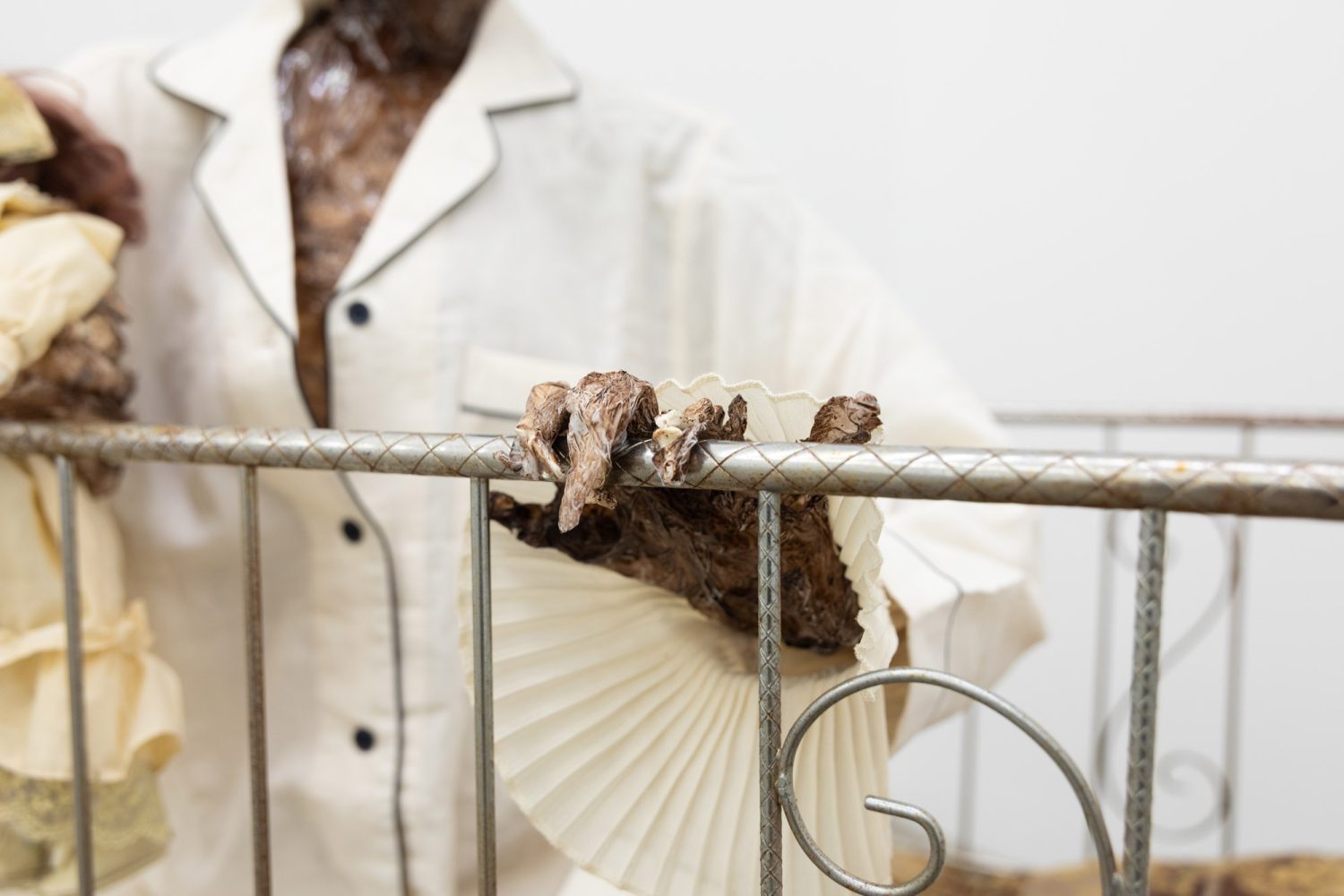 Julien Ceccaldi, Growing up Gay, 2026, Crib, comforter, plastic skeleton, melted drop cloth, wood stain, wig, acrylic paint on duralar, fake eyelashes, pyjama, and video game controller, courtesy of COOPER COLE