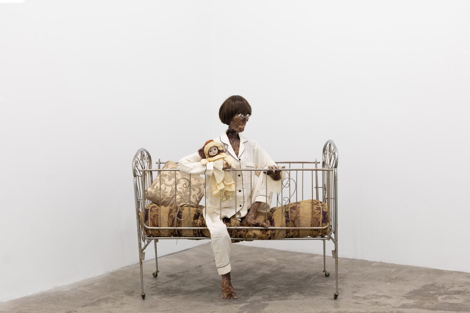 Julien Ceccaldi, Growing up Gay, 2026, Crib, comforter, plastic skeleton, melted drop cloth, wood stain, wig, acrylic paint on duralar, fake eyelashes, pyjama, and video game controller, courtesy of COOPER COLE