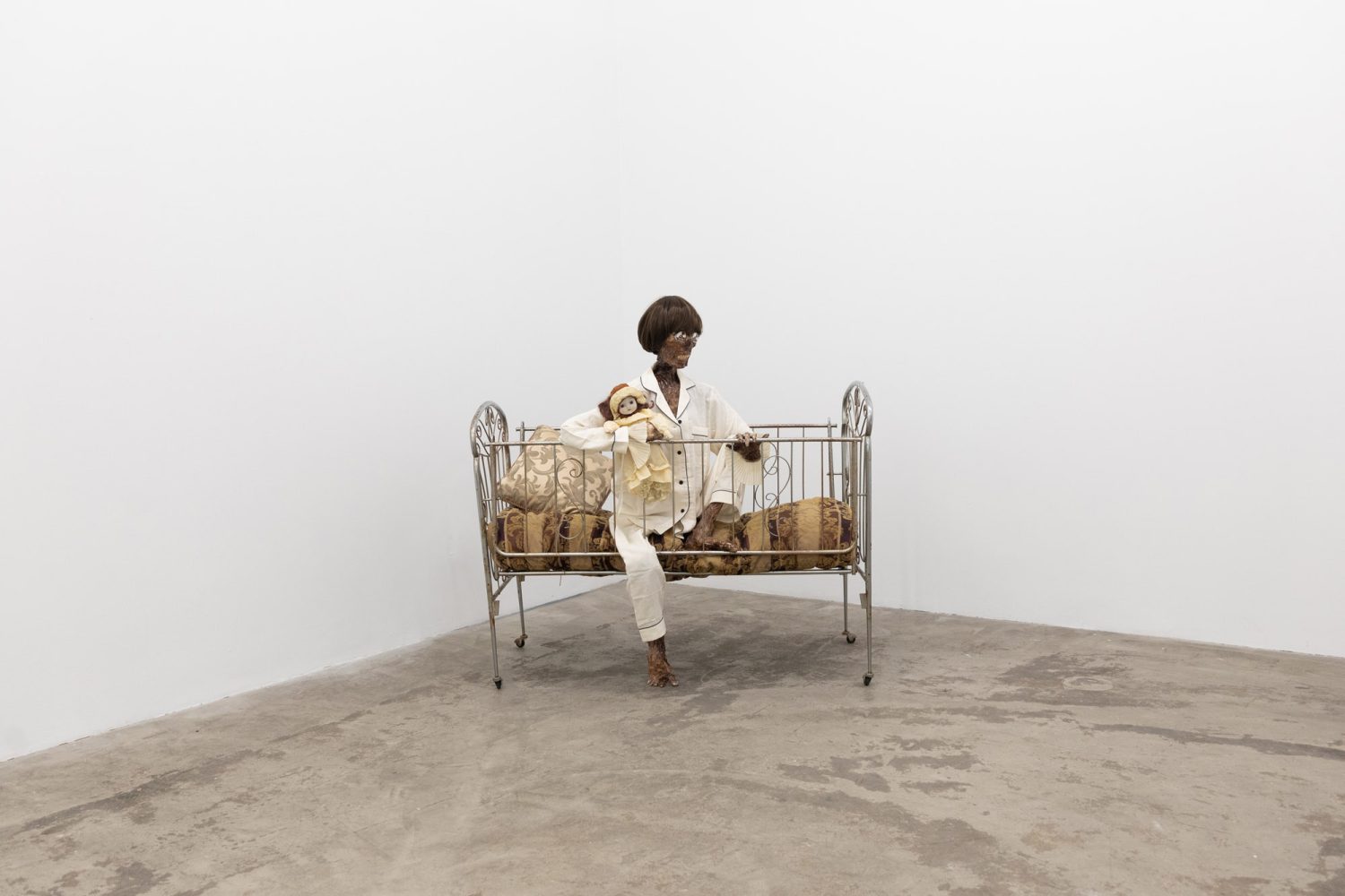 Julien Ceccaldi, Growing up Gay, 2026, Crib, comforter, plastic skeleton, melted drop cloth, wood stain, wig, acrylic paint on duralar, fake eyelashes, pyjama, and video game controller, courtesy of COOPER COLE